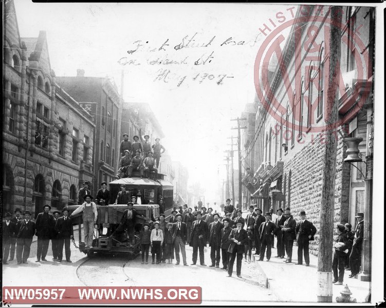 Group of men at Bluefield, WV with Tri-City Traction street car. First Street Bank on left.