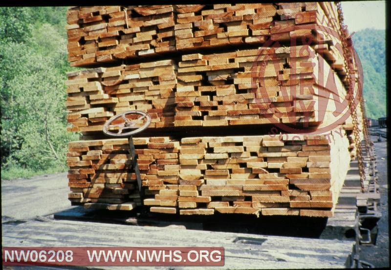 Shifted load of lumber on flat car with bent hand brake